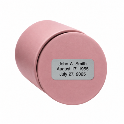 Blush Pink ceramic keepsake urn shown on its side with optional personalized memorial engraving plate