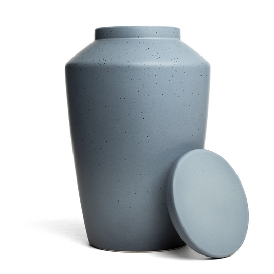 View of a speckled gray ceramic funeral urn with lid removed.