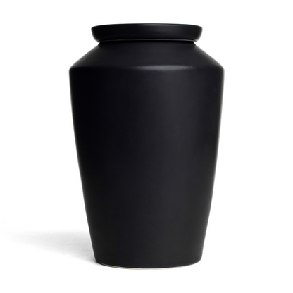 Handmade matte black ceramic cremation urn for adult ashes, minimalist modern memorial vessel for home decor.