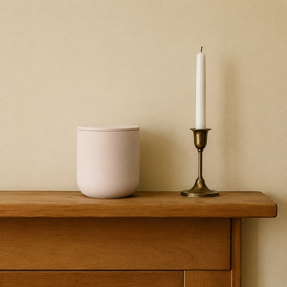 Soft Pink ceramic keepsake urn displayed on a wooden mantel beside a candle in a home memorial setting